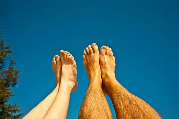 Been en voeten van man en kind met blauwe hemel — Stockfoto