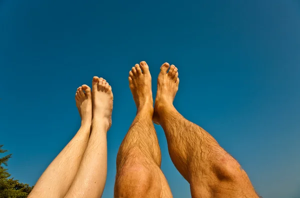 Ben och fötter av man och barn med blå himmel — Stockfoto