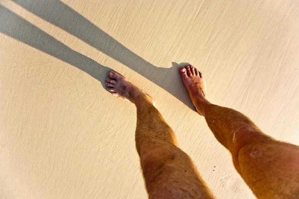 Hosszú test árnyék egy ember a finom homokos strand, lába van — Stock Fotó