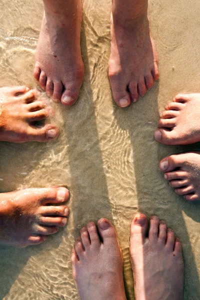 Pés de uma família na areia fina da praia, agrupados em um c — Fotografia de Stock