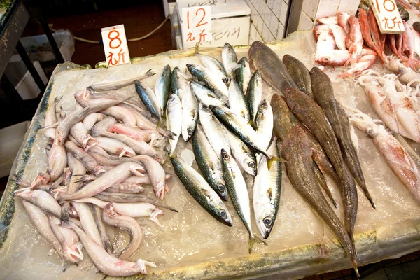 Peces frescos enteros se ofrecen en el mercado de pescado en Asia — Foto de Stock