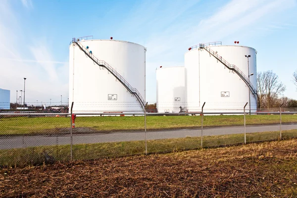 Tanques blancos para gasolina y aceite en granja de tanques con cielo azul — Foto de Stock
