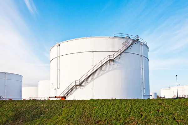 Bílé nádrže na benzín a olej na tankové farmě s modrou oblohou — Stock fotografie