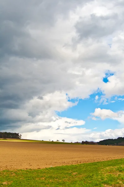 Dark clouds and blue sky over fields — Stock Photo, Image