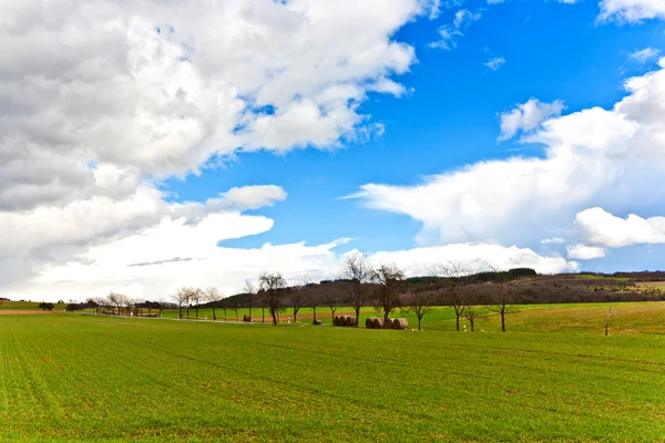 Dunkle Wolken über Feldern im Frühling — Stockfoto