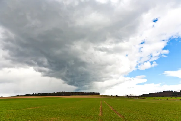 stock image Dark clouds over fields in spring