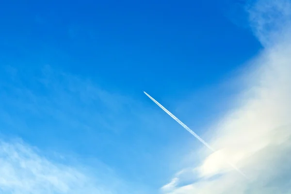 Blue sky with condensation trail of an aircraft — Stock Photo, Image