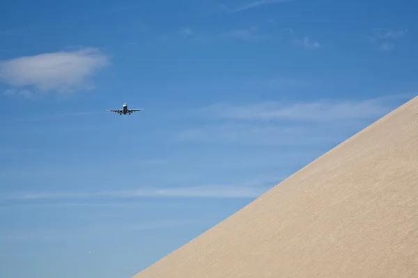 Štěrk pit hill s blížící se letadlo — Stock fotografie