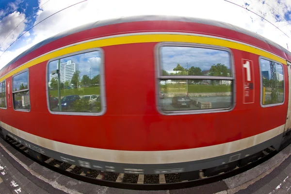 Красный поезд движется по станции — стоковое фото