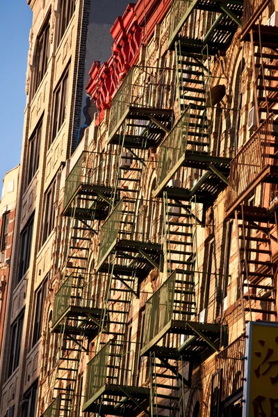 Old iron fire escape rescue ladders at old houses — Stock Photo, Image