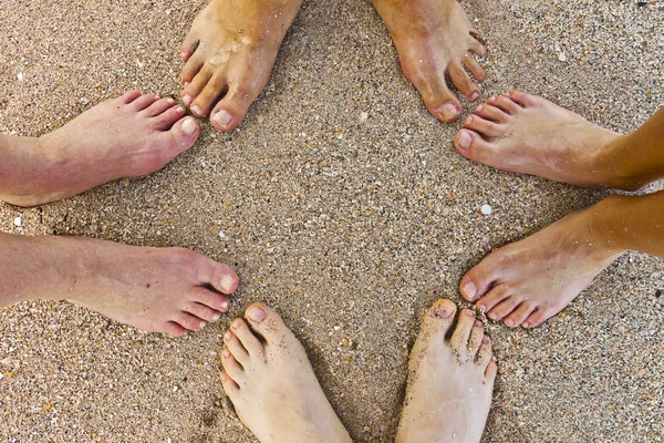 Fötter av familjen på stranden — Stockfoto