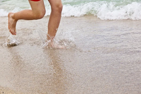 Pés de menino correndo pela praia — Fotografia de Stock