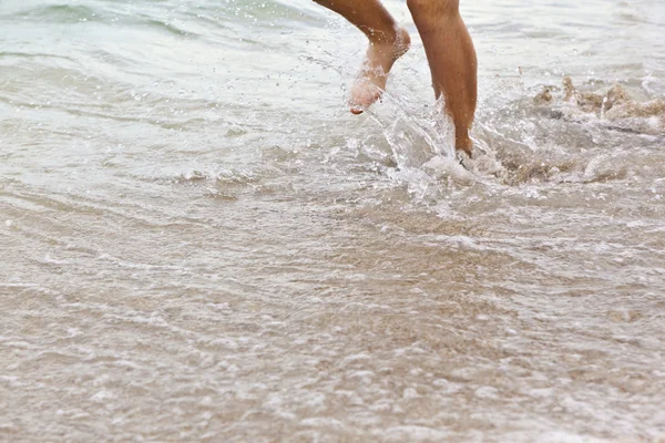 Füße des Jungen laufen am Strand entlang — Stockfoto