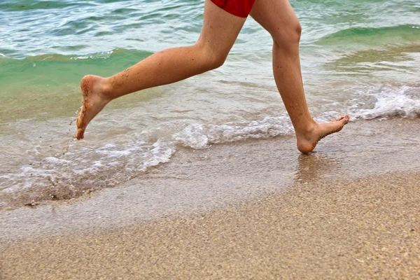 Plaj boyunca çalışan bir çocuğun ayakları — Stok fotoğraf
