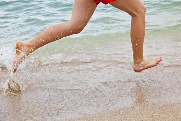Feet of boy running along the beach — Stock Photo, Image