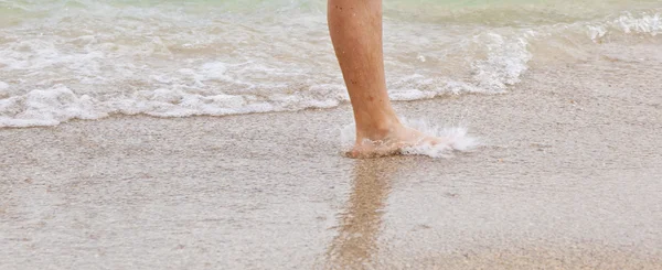 Voeten van jongen loopt langs het strand — Stockfoto