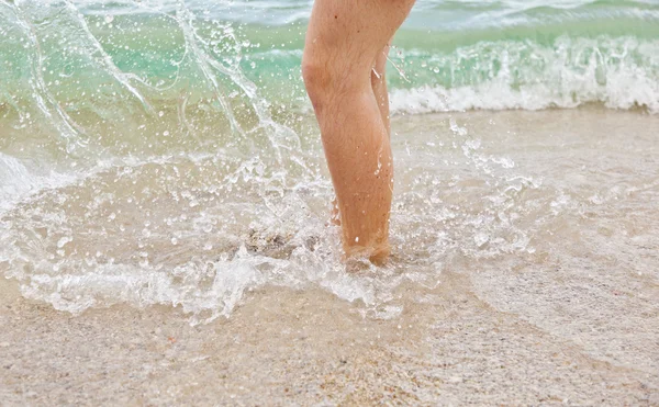 Voeten van jongen springen in het water — Stockfoto