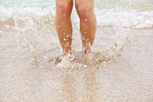 Nohy chlapce podél pláže — Stock fotografie