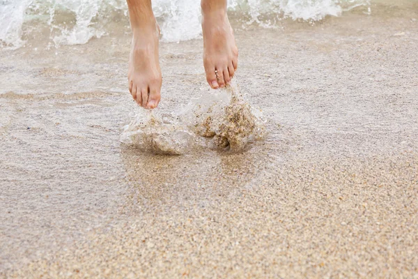 Fötter av pojke hoppar i vattnet — Stockfoto