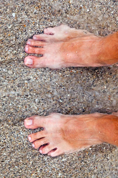 Füße des Mannes am Strand — Stockfoto