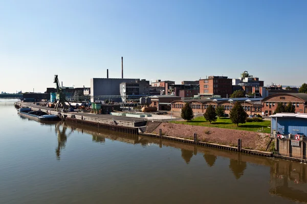 Staré průmyslové budovy na řece — Stock fotografie