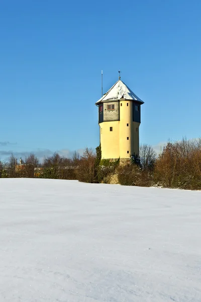 Torre de agua en campos cubiertos de nieve — Foto de Stock