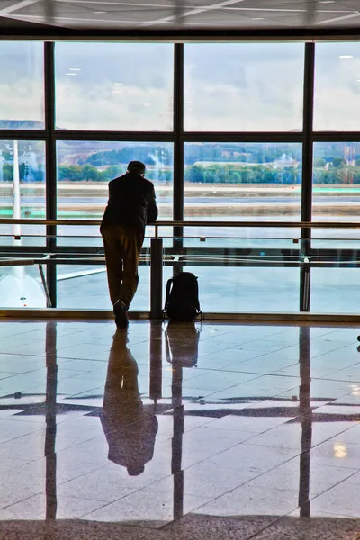 Człowiek czeka wyjazd jego lotu — Zdjęcie stockowe