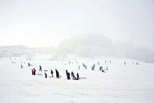 Τα παιδιά πατινάζ στο τόμπογκαν το χειμώνα στο χιόνι — Φωτογραφία Αρχείου