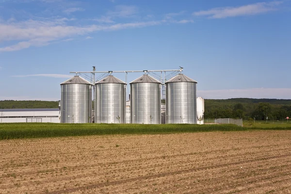 Silver shining silo with acre in landscape Stock Image