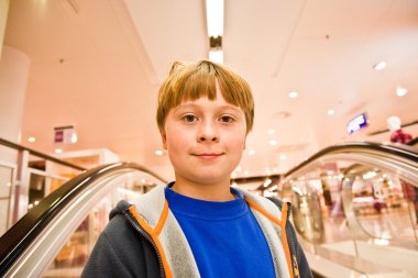 Child on moving staircase looks self confident clipart