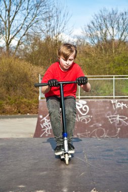 çocuk onun scooter sürme ve atlama sahiptir