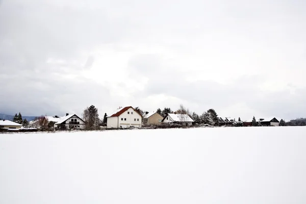 Плотина с домами и снегом зимой — стоковое фото