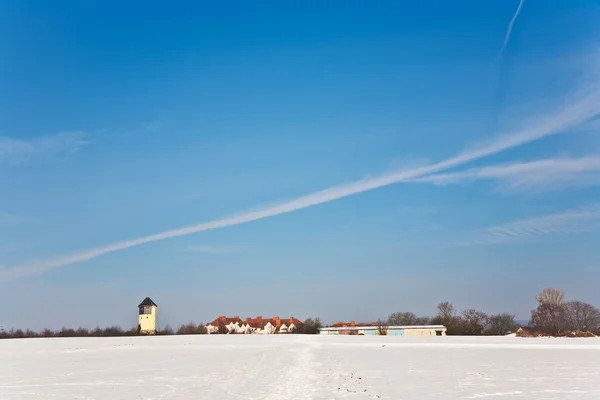 Пейзаж с водонапорной башней и жилой зоной зимой — стоковое фото