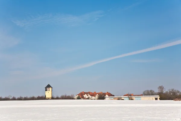 Пейзаж с водонапорной башней и жилой зоной зимой — стоковое фото