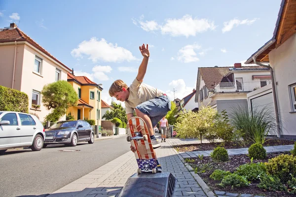 Мальчик на скейтборде летит по тротуару — стоковое фото
