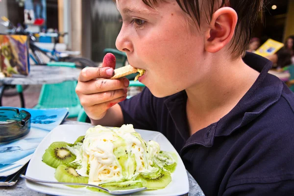 Niño está comiendo helado en una mesa al aire libre —  Fotos de Stock