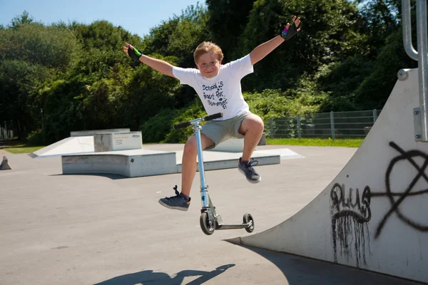 少年は、スケート公園でスクーターに乗る — ストック写真