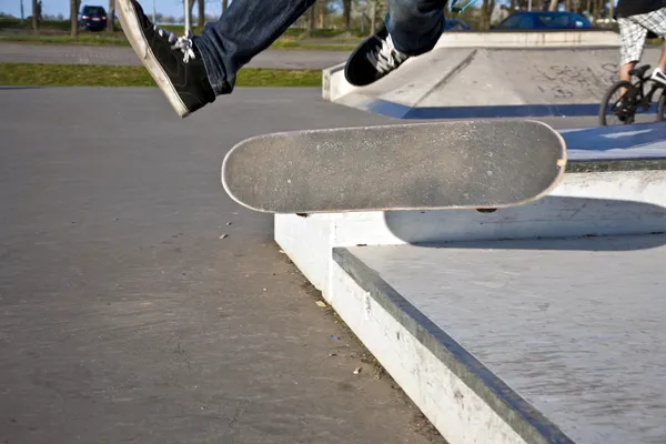 Junge mit Skateboard fliegt in die Luft — Stockfoto