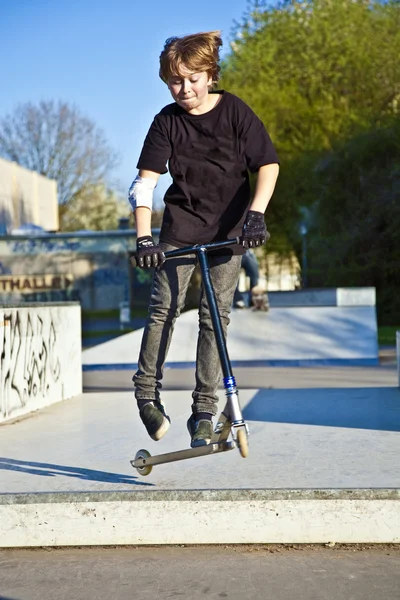 Boy with scooter is going airborne — Stock Photo, Image