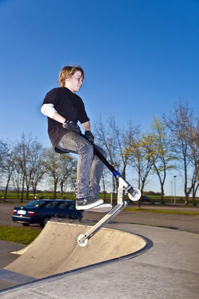 Junge mit Roller fliegt in die Luft — Stockfoto