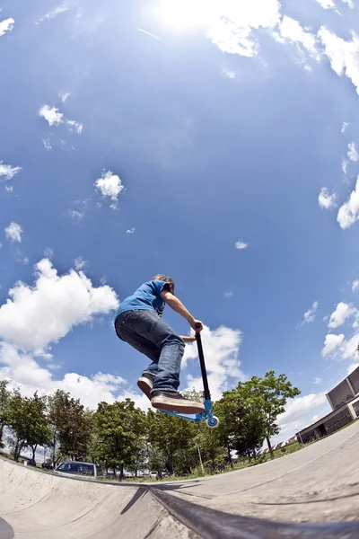 Chico se divierte con scooter en el parque de skate —  Fotos de Stock