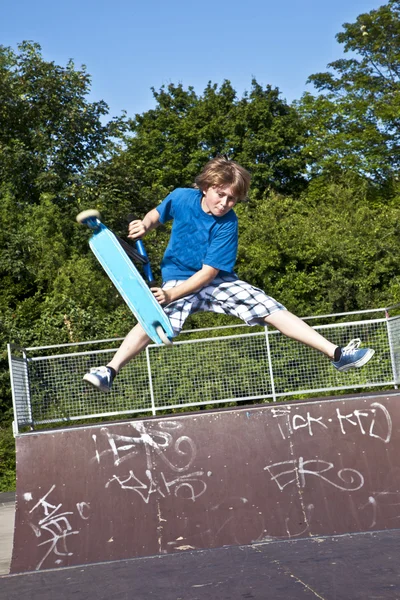 Ung pojke kommer luften med en skoter — Stockfoto