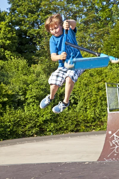 Junge fliegt mit Roller in die Luft — Stockfoto