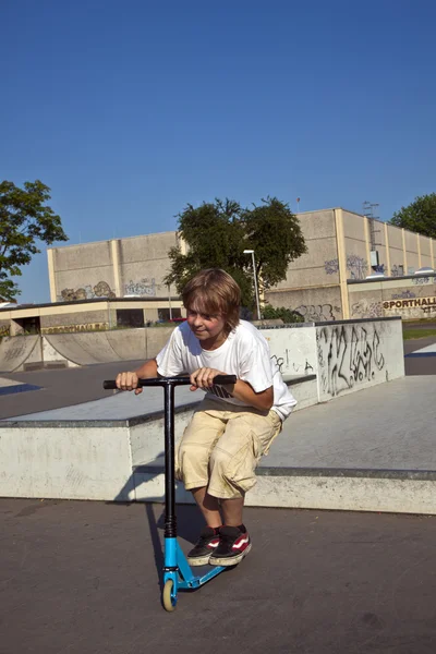 Boy with scooter is going airborne — Zdjęcie stockowe