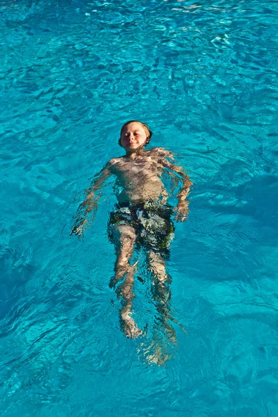 Счастливый ребенок плавает в бассейне — стоковое фото