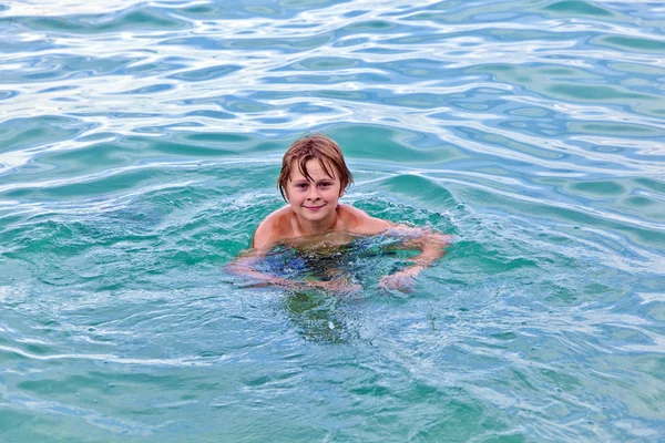 Niño está nadando en el océano —  Fotos de Stock