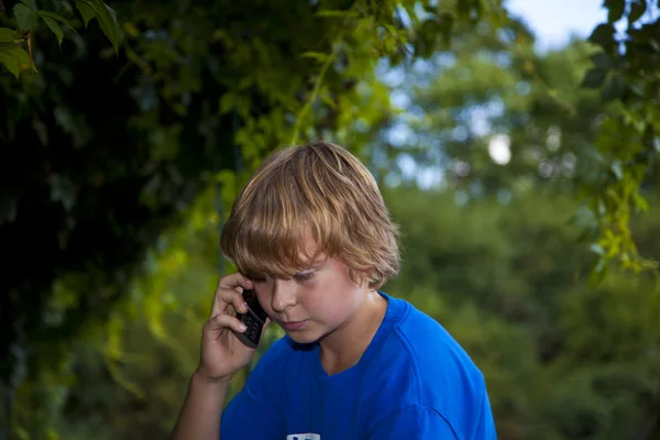 Jeune garçon parlant sur un téléphone portable . — Photo