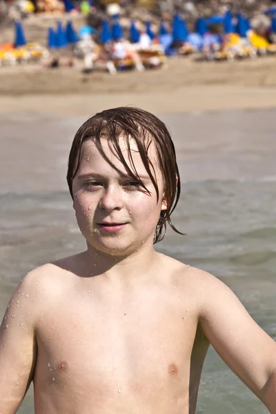 Chlapec má zábavu na pláži ve vlnách — Stock fotografie