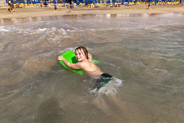 Мальчик веселится на пляже на волнах — стоковое фото