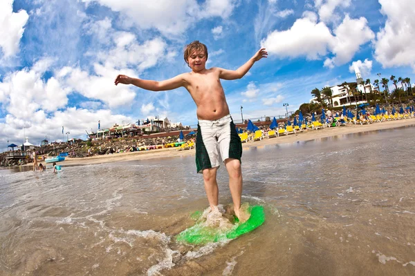 Pojken har kul på stranden — Stockfoto